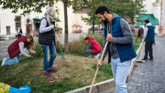 Young guy working with his community group raking